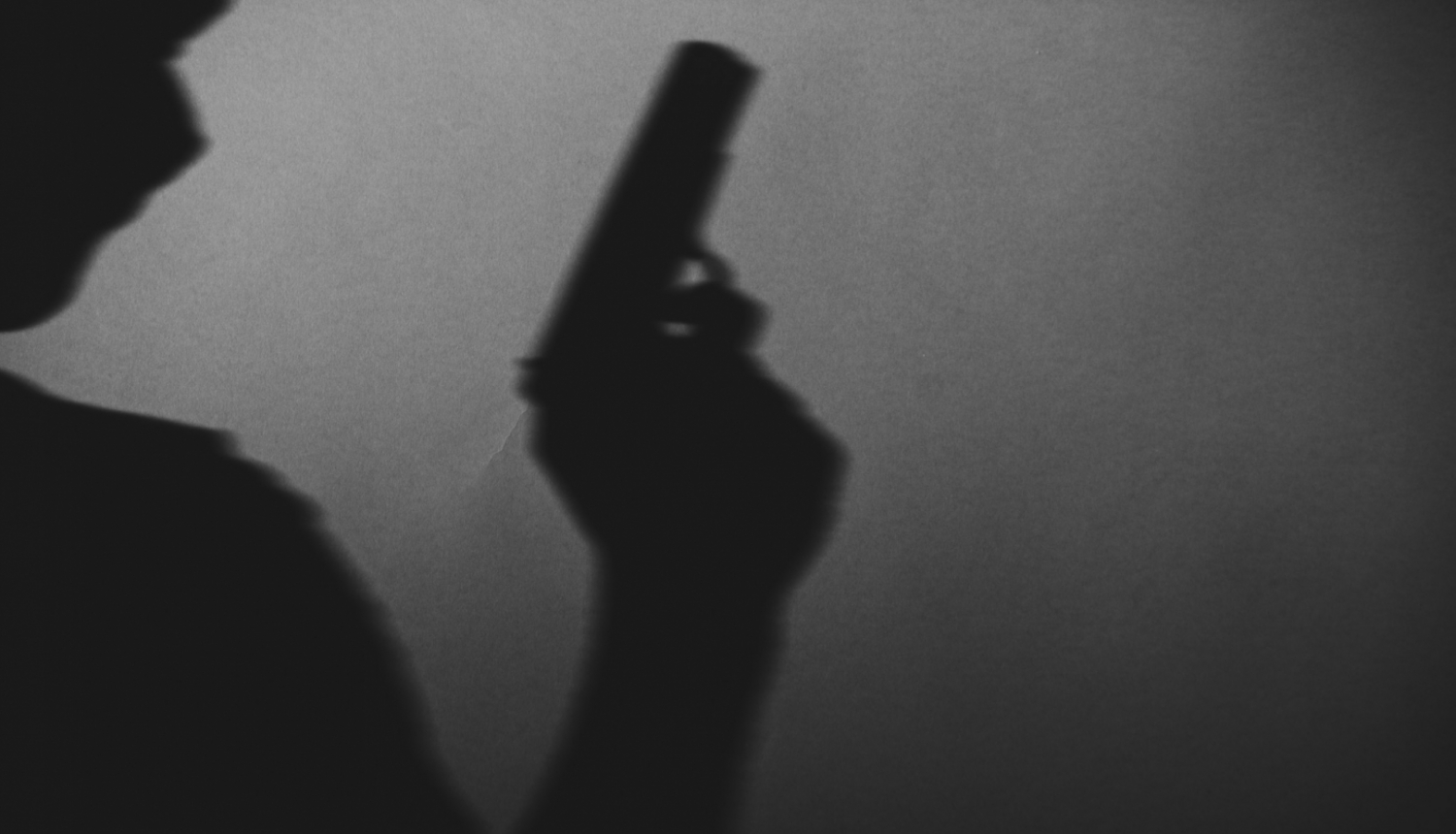 Cilvēka siluets ar ieroci rokā